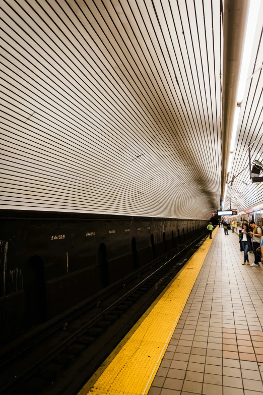 people are waiting on the train platform for it to arrive