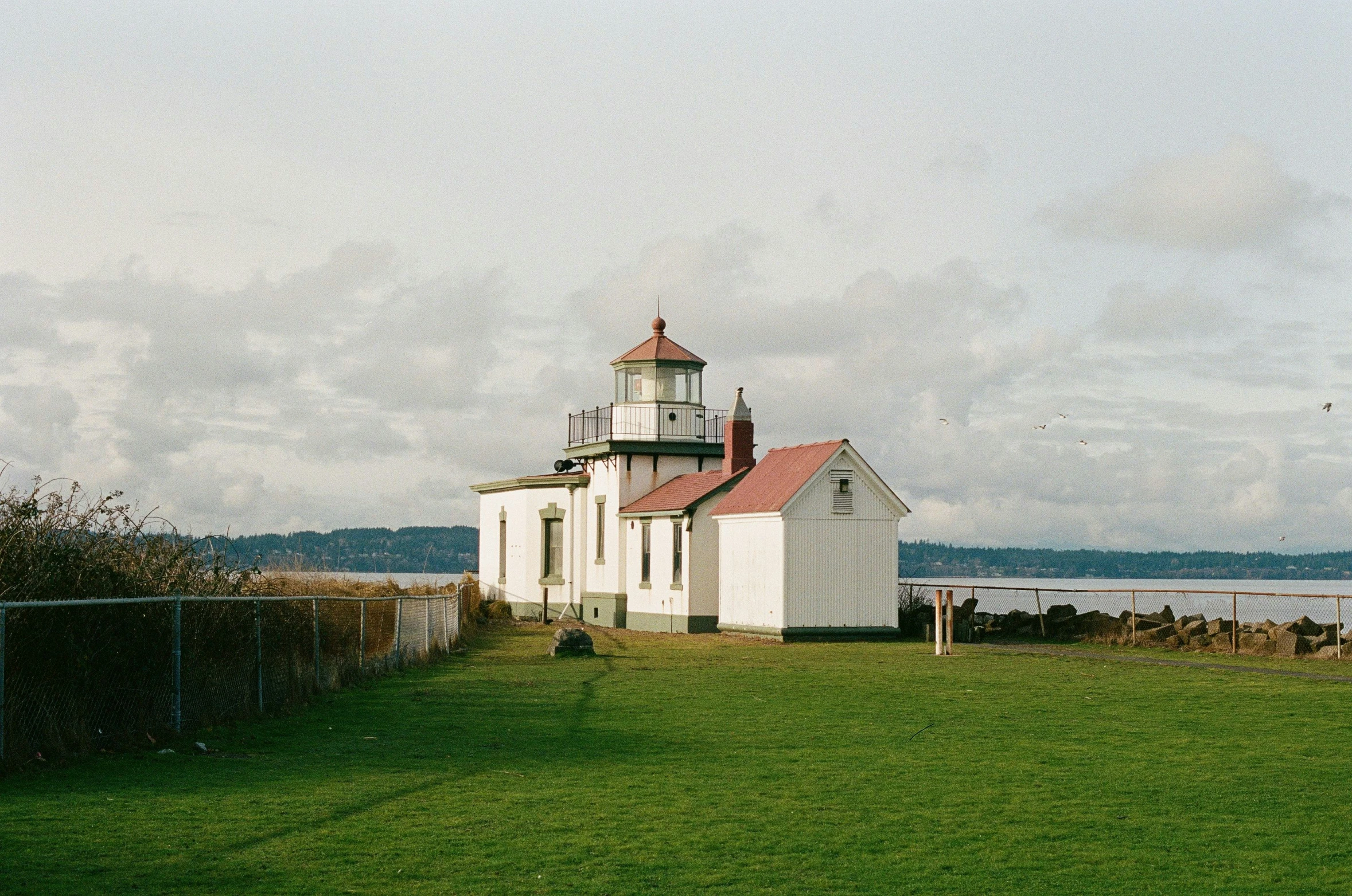 a small white building is near the water