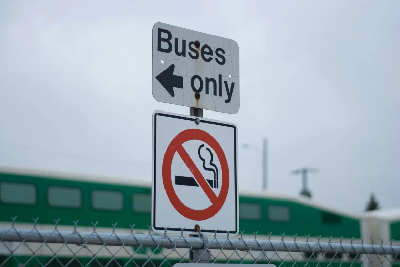 a close up of street signs on a metal fence