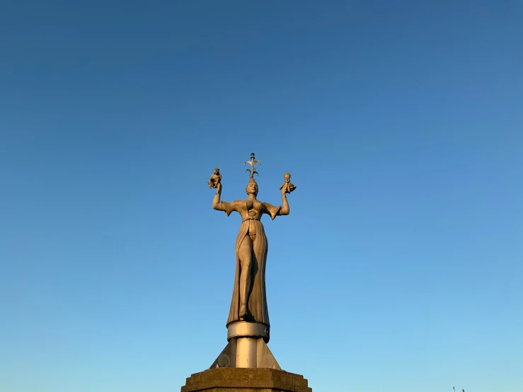 a tall statue is sitting outside against a blue sky