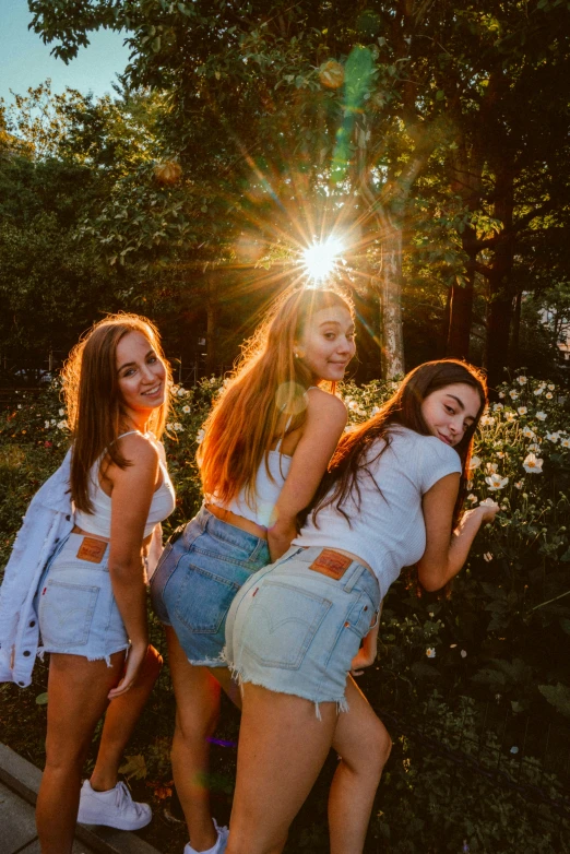 three girls pose next to each other in their sun - beaming poses