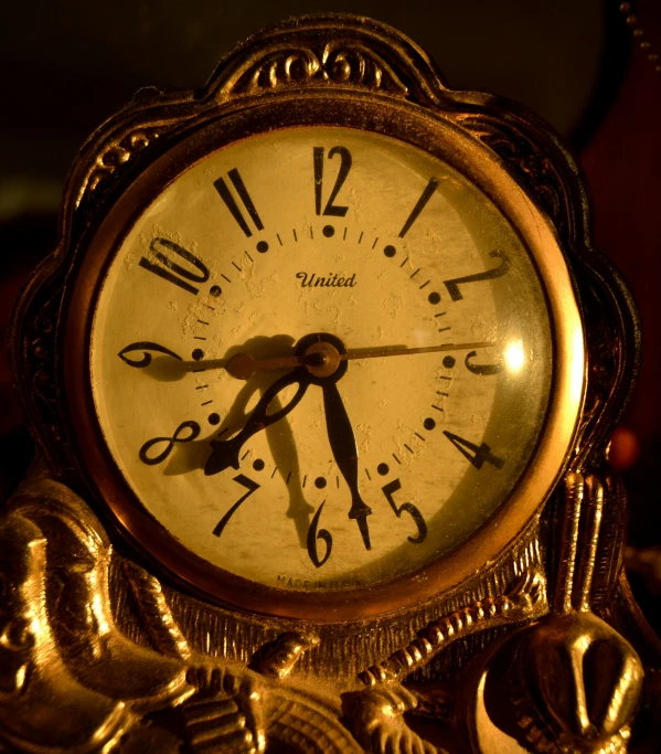 the gold clock is surrounded by other metal objects