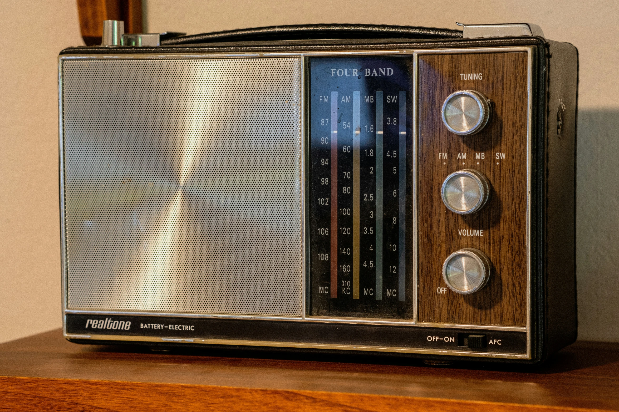 an old fashioned radio on top of a wooden shelf