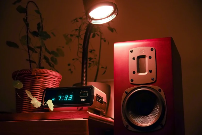 a clock is on a red and black speaker