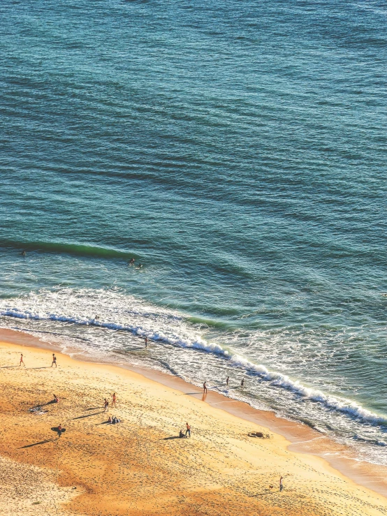 people in the ocean looking at an empty beach