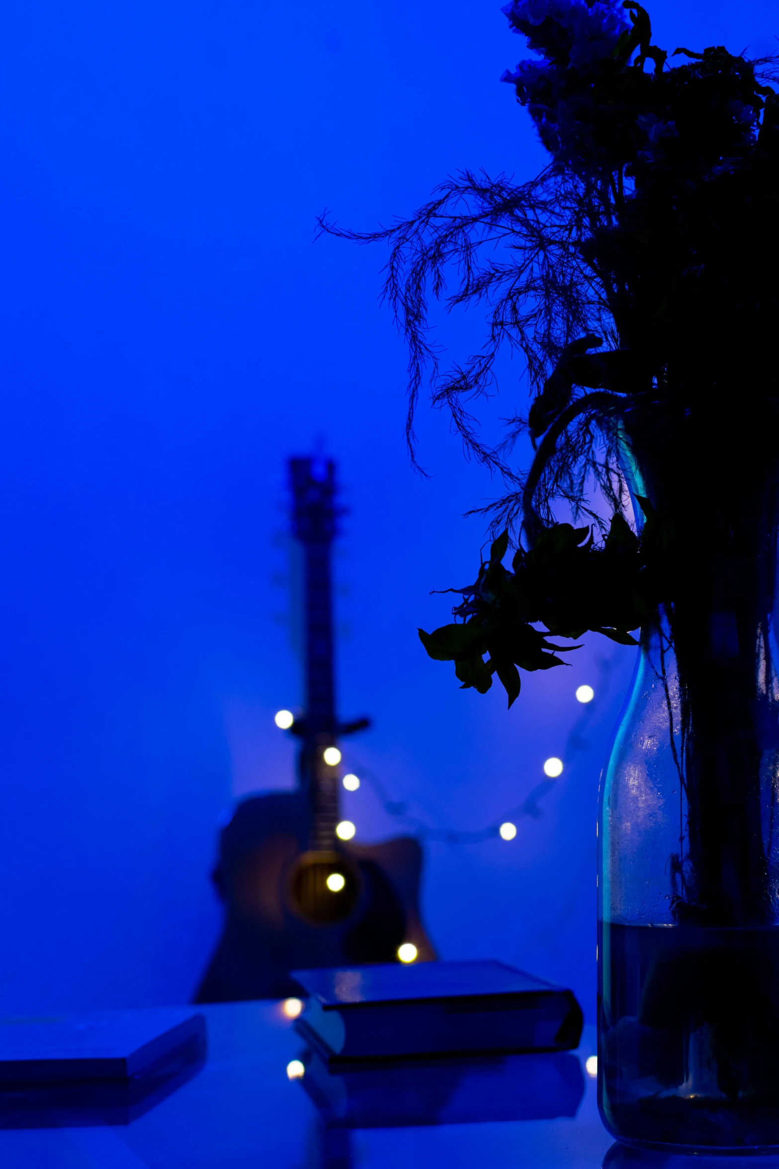 a guitar is on a table near a vase