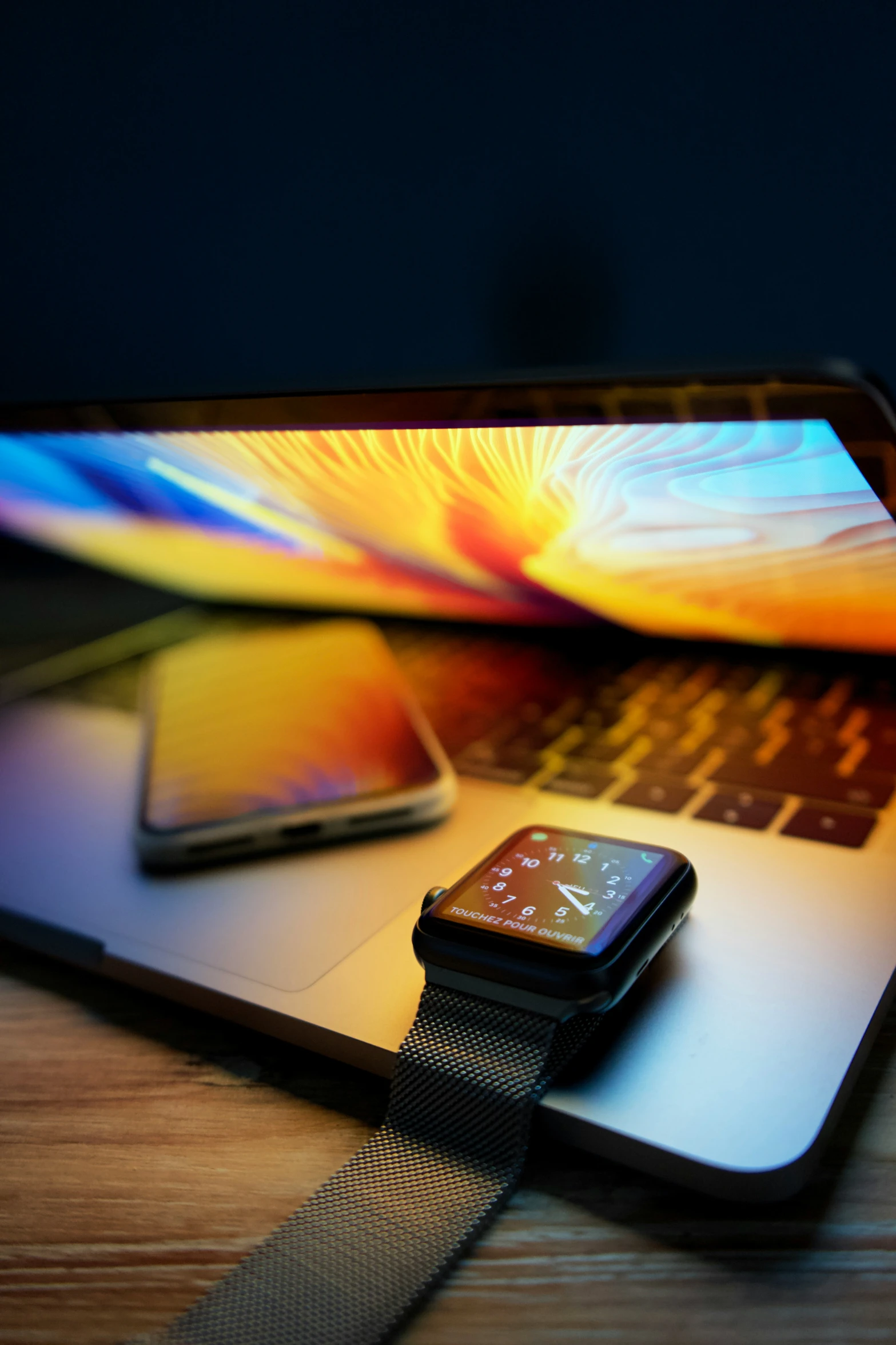 an open laptop sitting on top of a table with an iphone