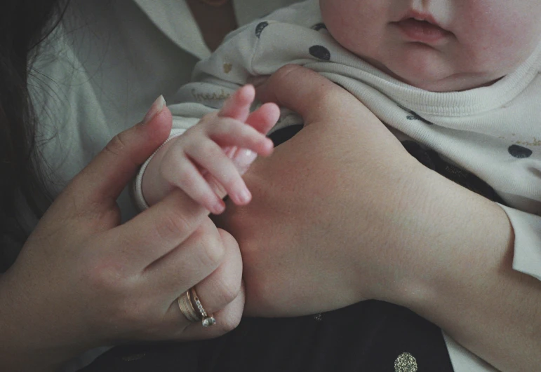 a small child holding in a woman's hands