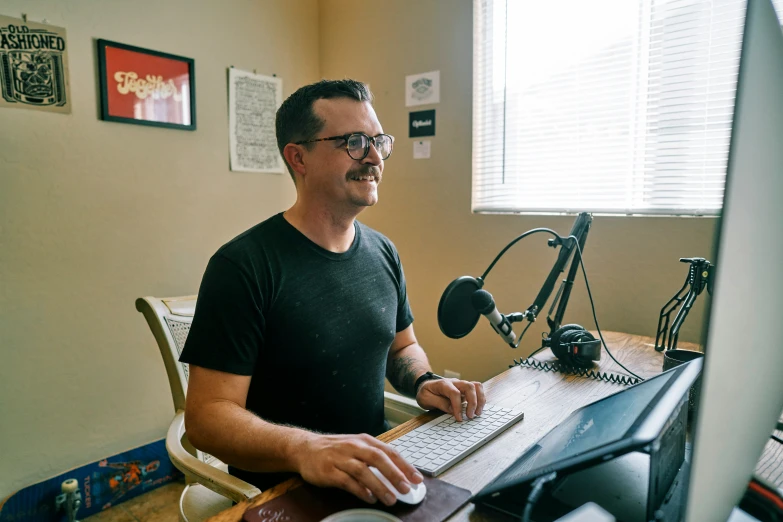 man sitting at computer at desk smiling at camera