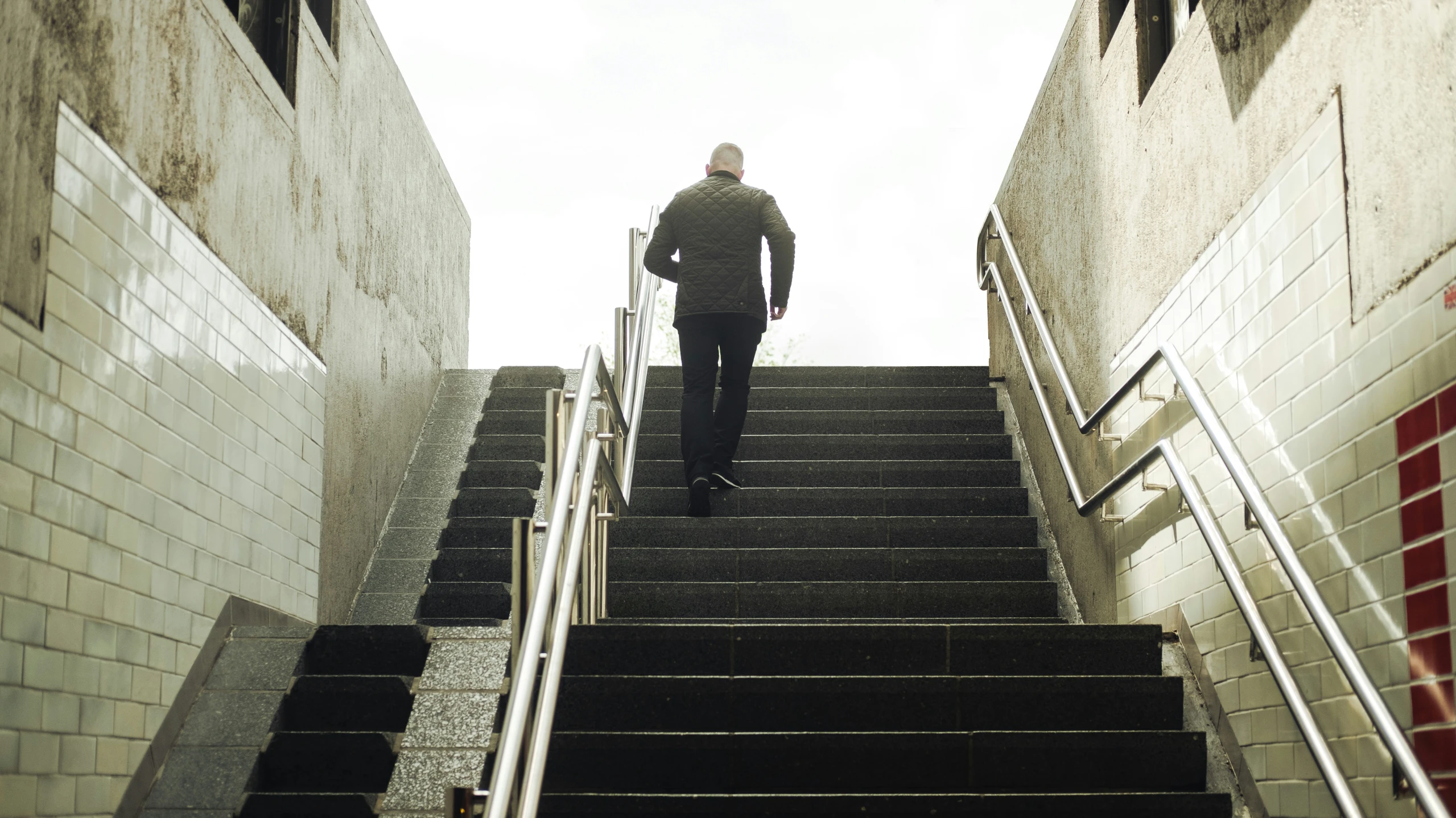 a man climbing a set of stairs with his luggage