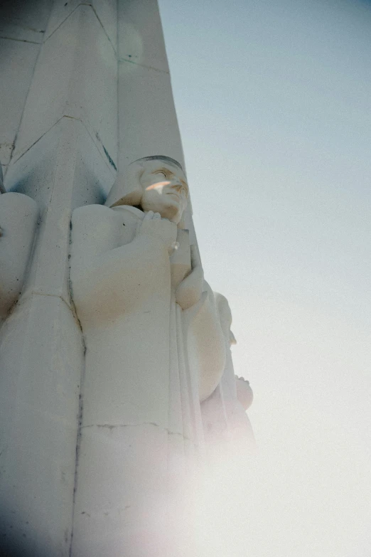 the top of a white statue that looks like jesus holding a book