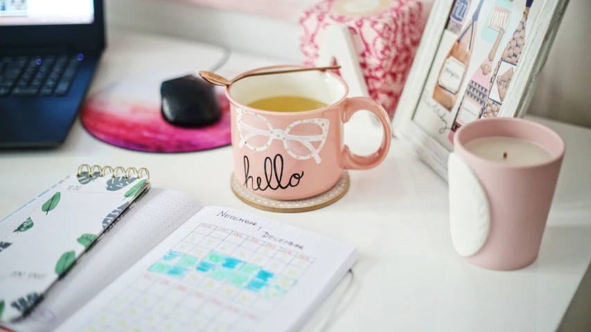 a cup of tea next to an open book on a table