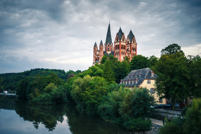 a castle stands on top of a hill near a river