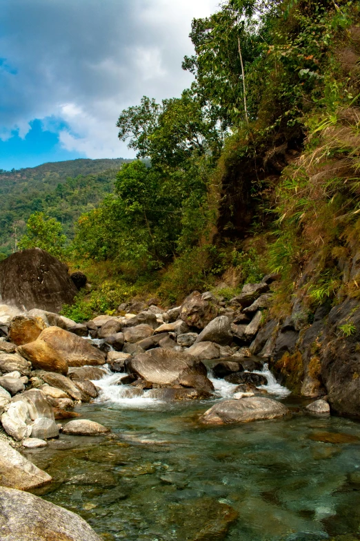 a river surrounded by rocks and trees next to a mountain