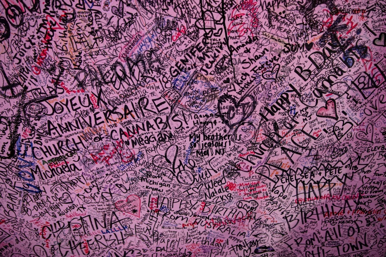 a wall covered with graffiti with the words all in pink