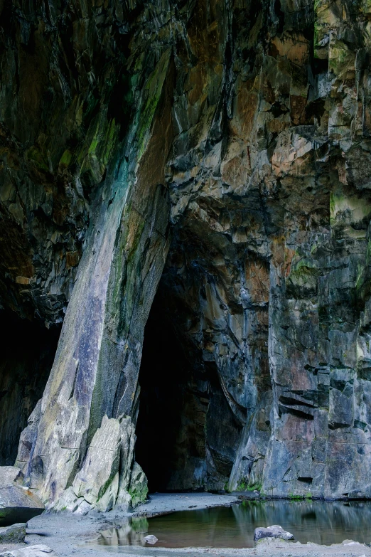 the entrance to a cave is flanked by rocks