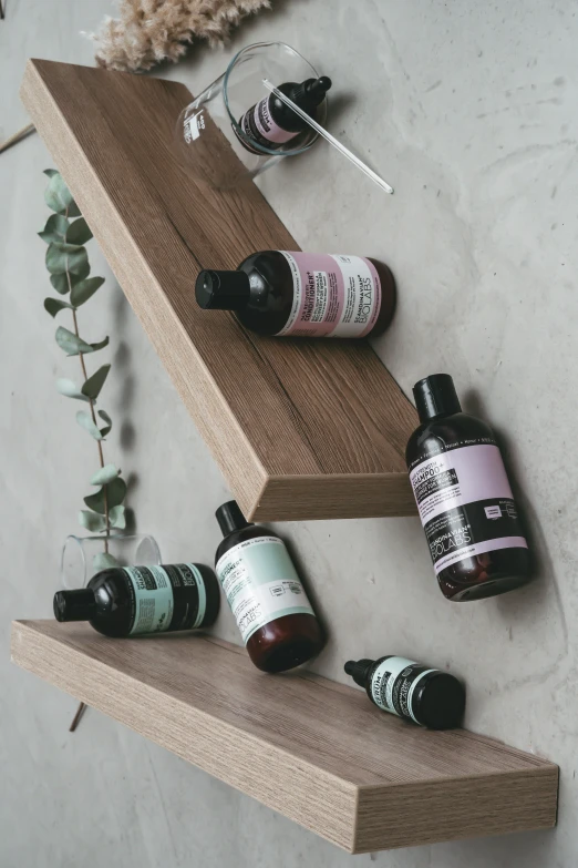 an assortment of different kinds of perfume bottles on a wooden shelf