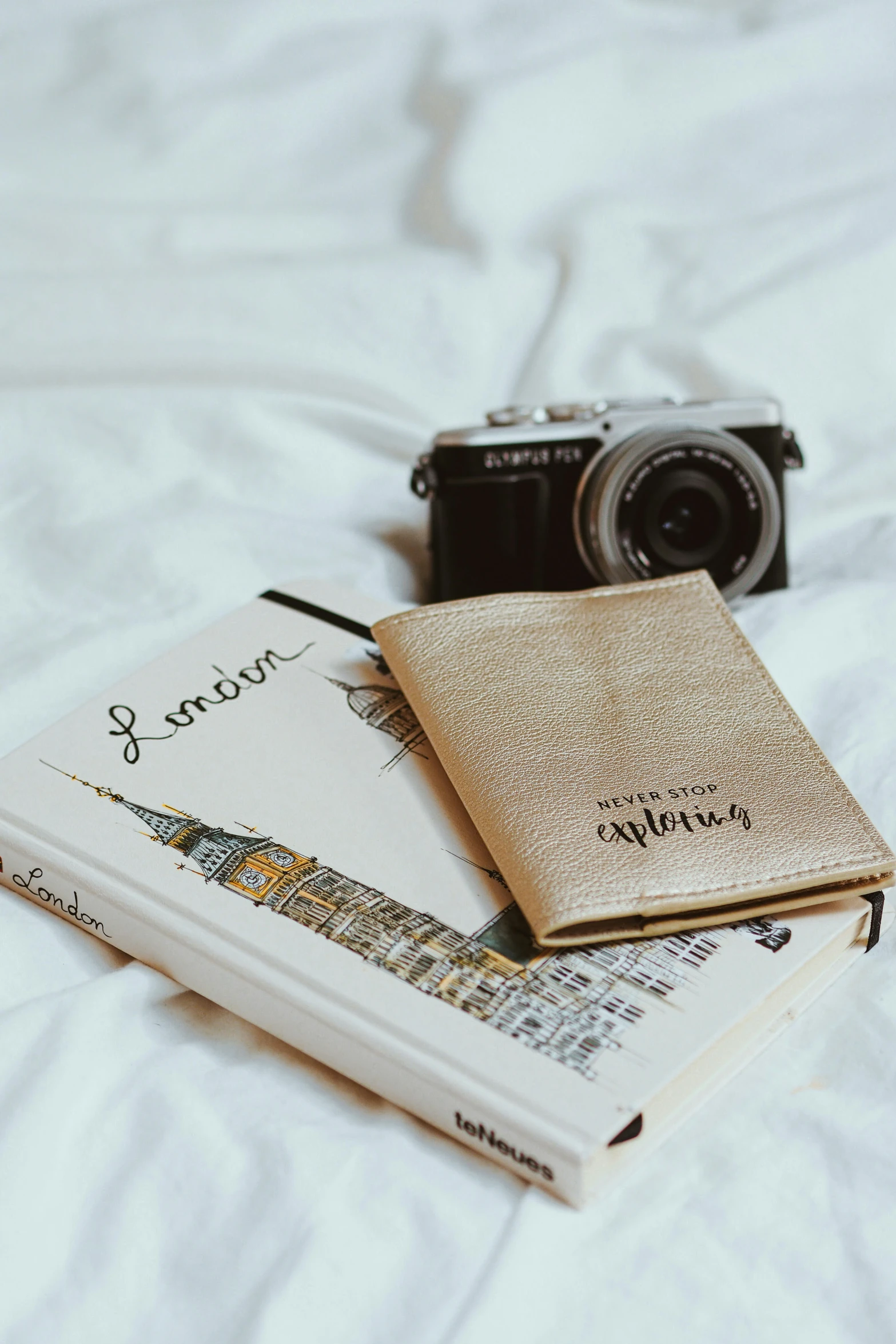 a camera and a book on top of a bed