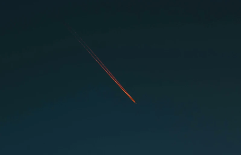 an airplane is in the sky with a trail of smoke