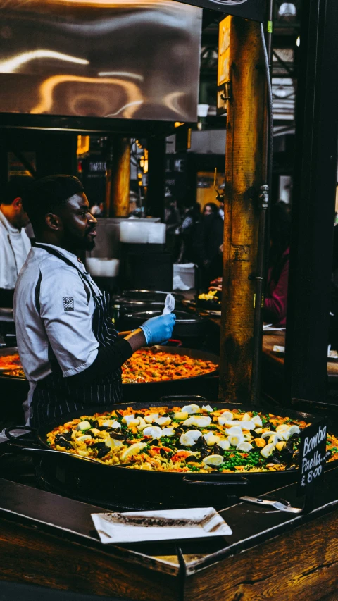 two men in chefs hats are serving out food to customers