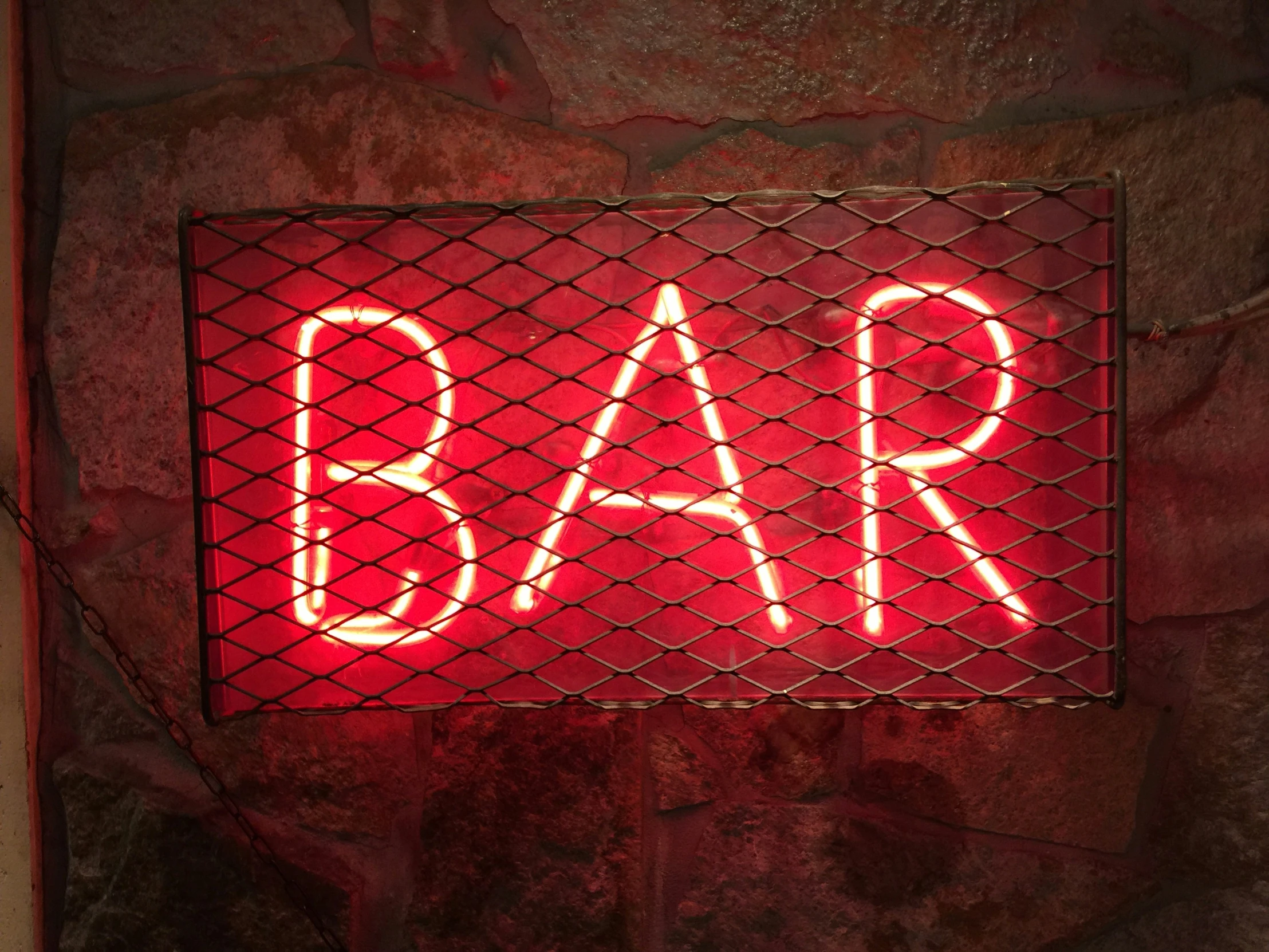 there is a neon bar sign on the wall