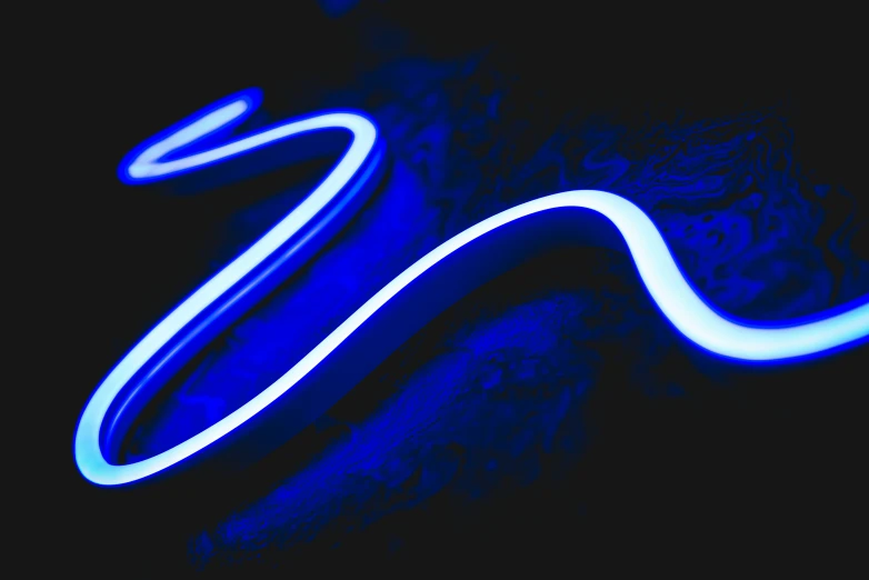 a neon blue light shines on a dark surface