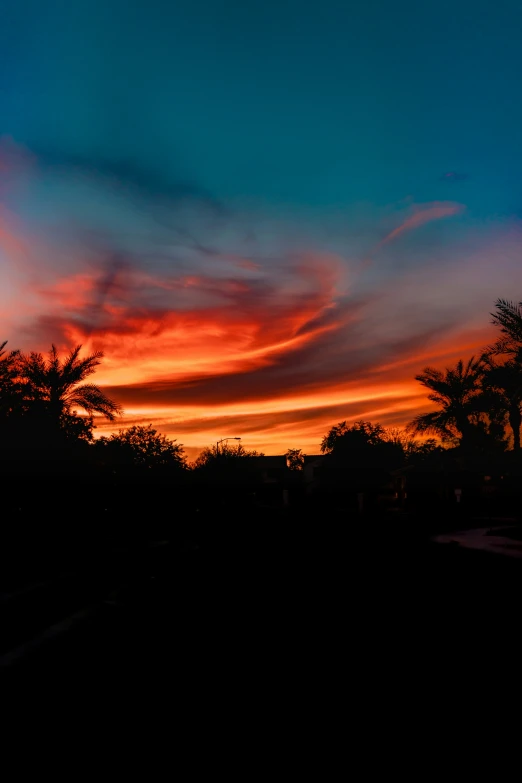 a red and blue sky with trees in the background