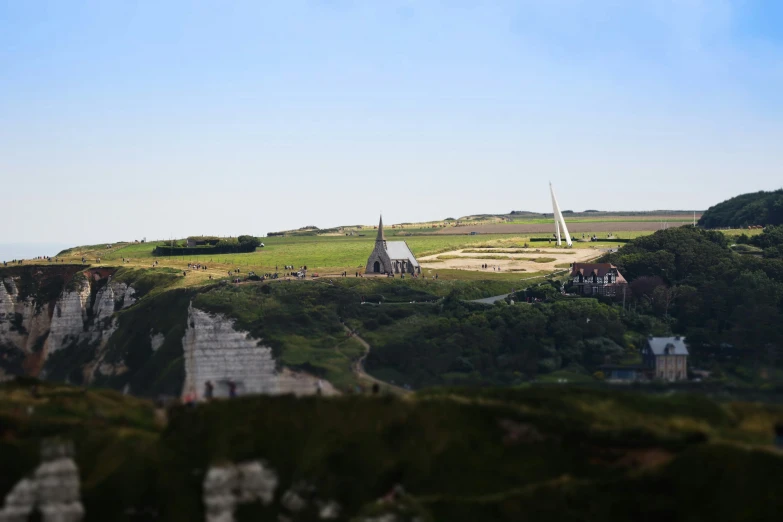 a small building on a hill top, with other buildings in the background