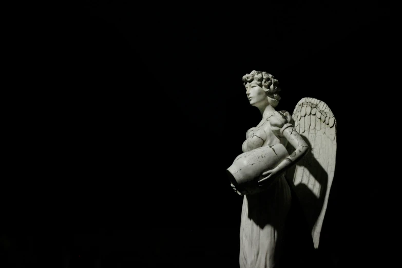 a small angel statue holding a baby