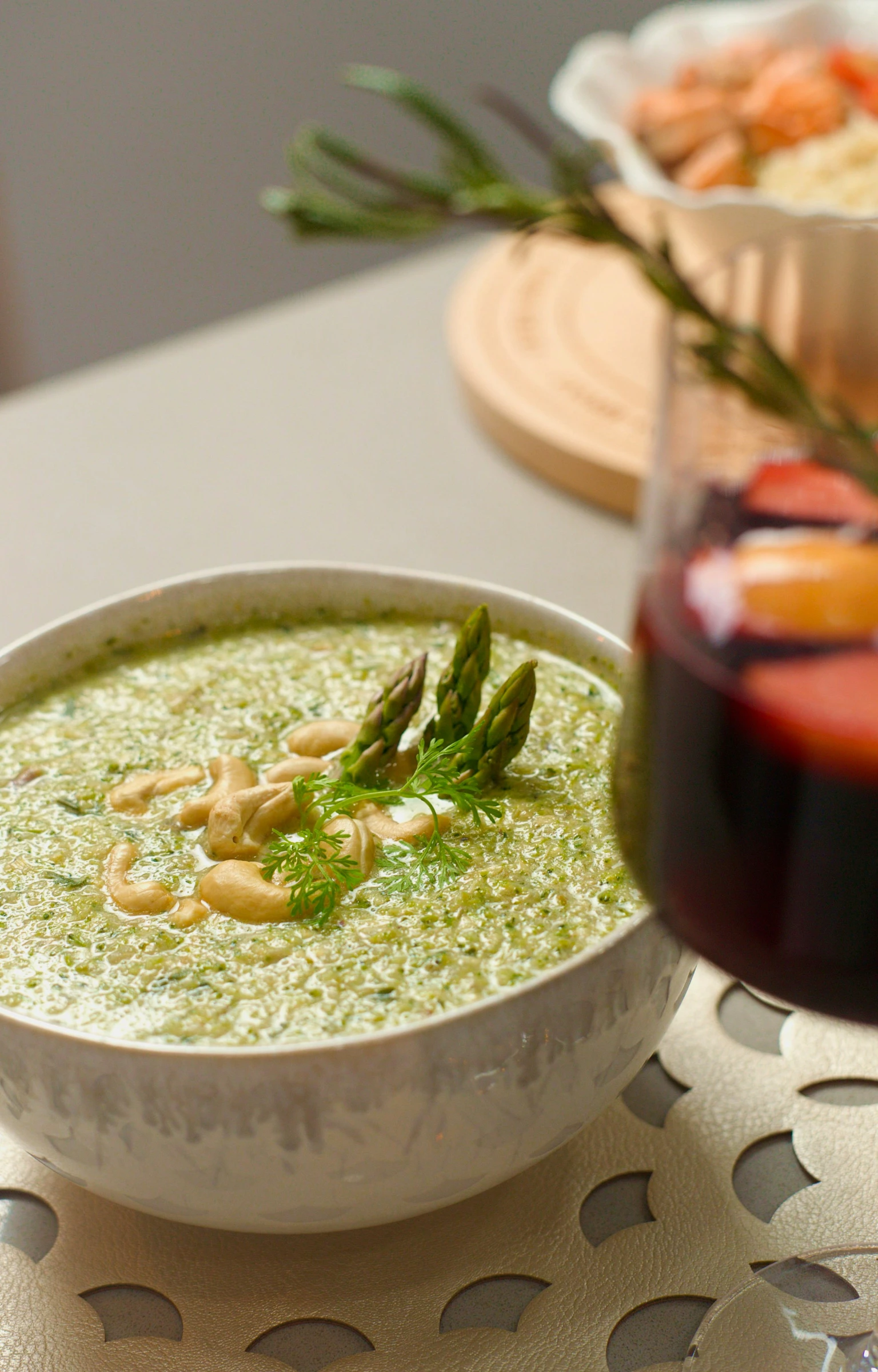 a white bowl full of broccoli soup with garnish on the edge