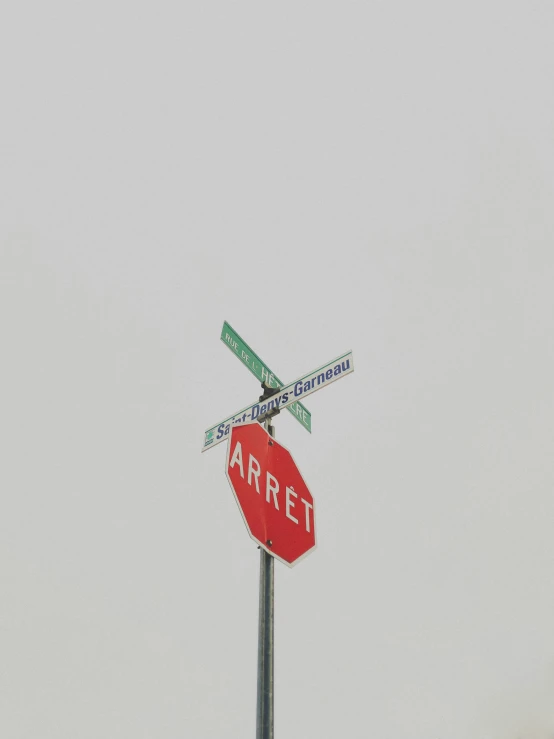 a stop sign that has street signs at the top of it