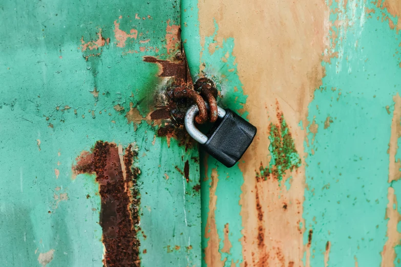 a padlock on the side of an old green building