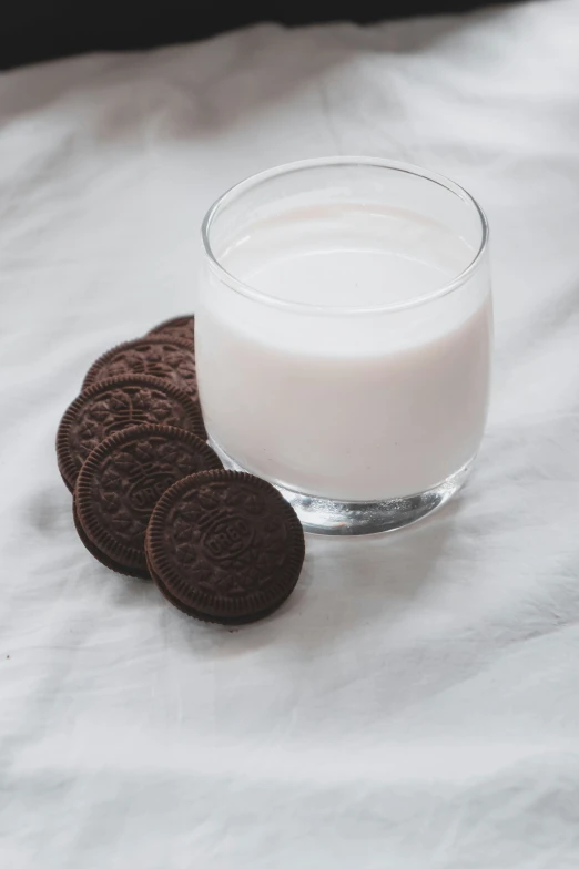 an oreo cookie sitting next to a glass of milk