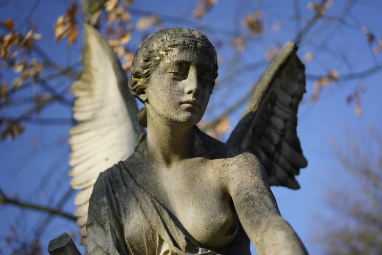 an angel statue with wings reaching up towards the sky