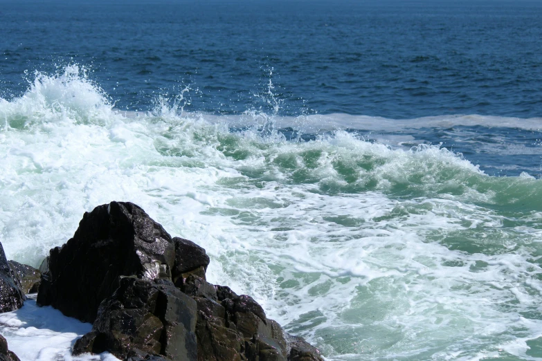 the waves are crashing against the rocky shore