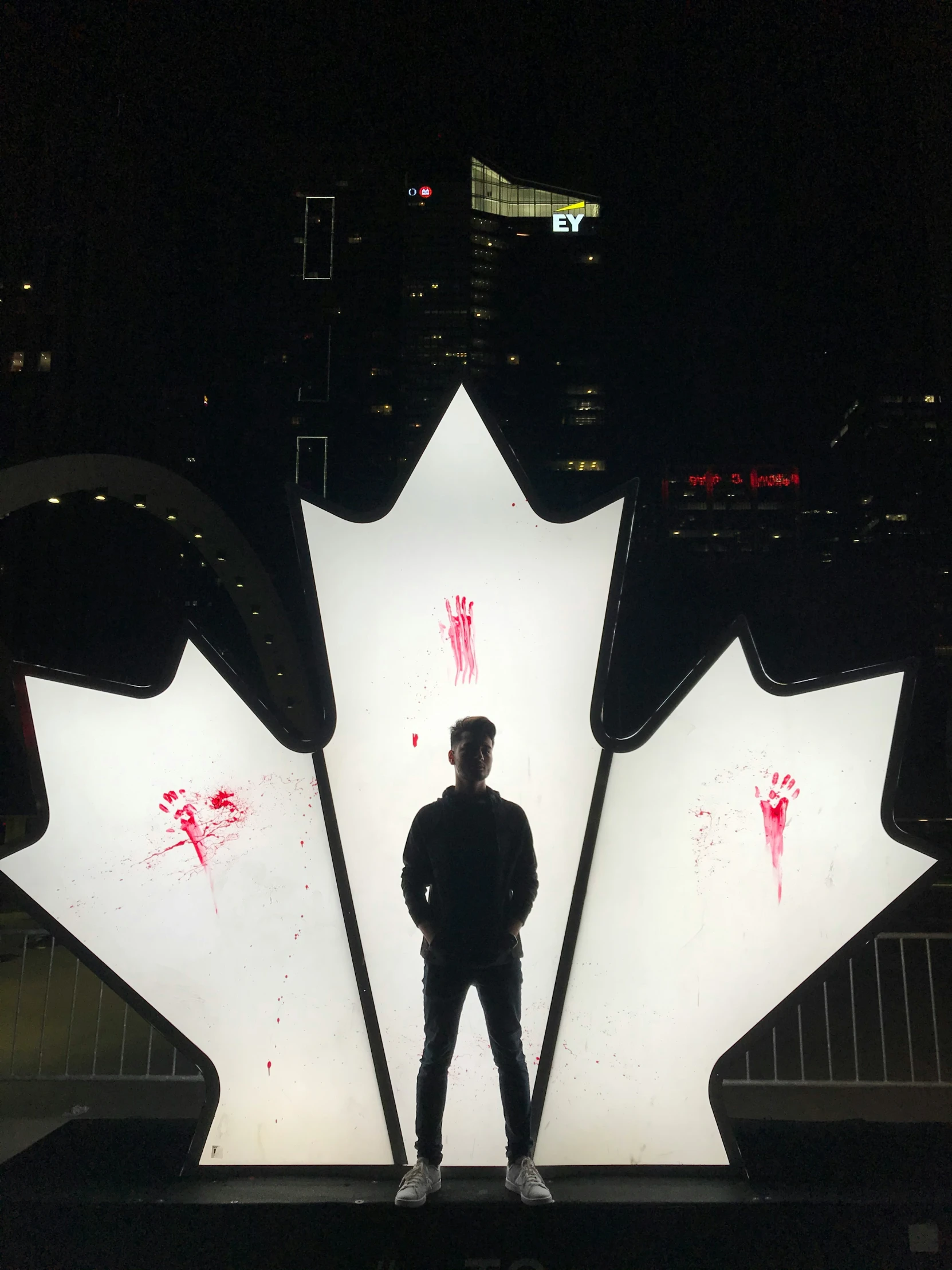 the man is standing in front of an illuminated maple leaf