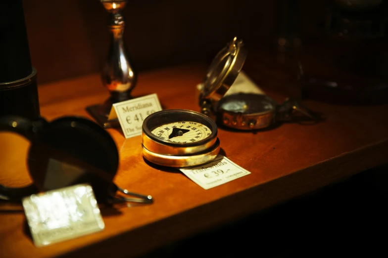 two ss compasses on a wooden table with cards