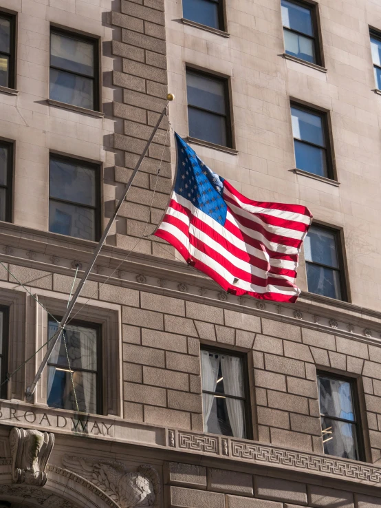 an american flag flies above a large building