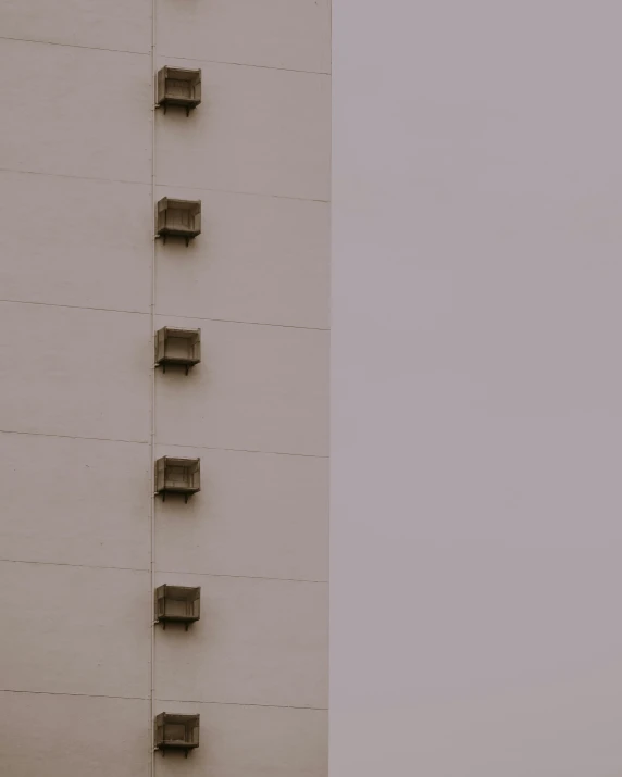 two tall white buildings with black electrical boxes on the side of them