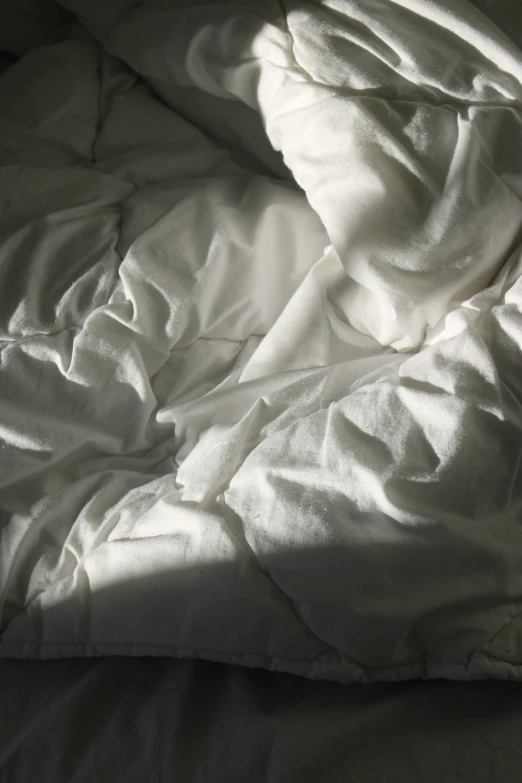 a white bed that is covered with some sheet material