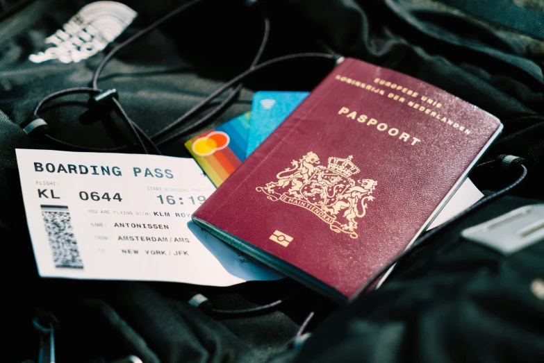 a red passports and a boarding pass sitting on top of a luggage bag