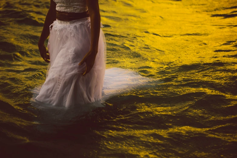 a woman in a white dress in water