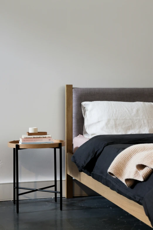 a bed with a wooden frame sitting in a bedroom