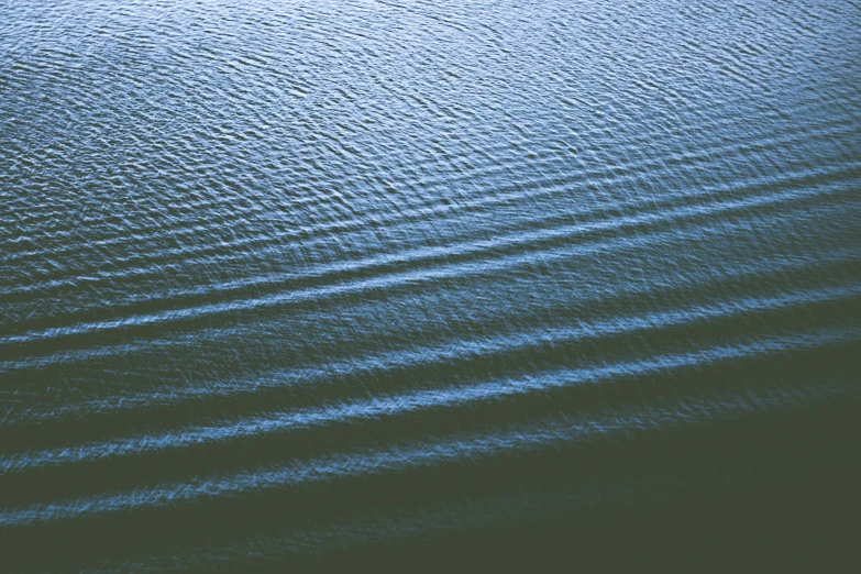 a very dark blue body of water with ripples