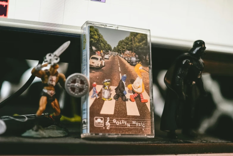 figurines in front of a musical cd on top of a counter