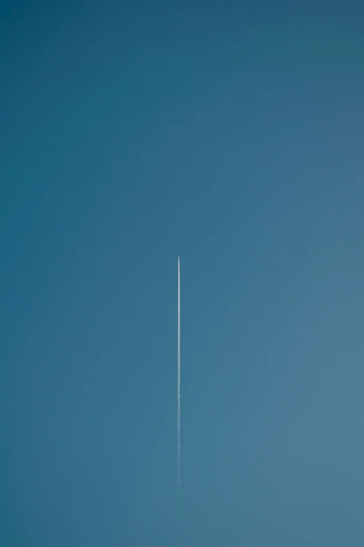 an airplane in the sky with its contrail visible