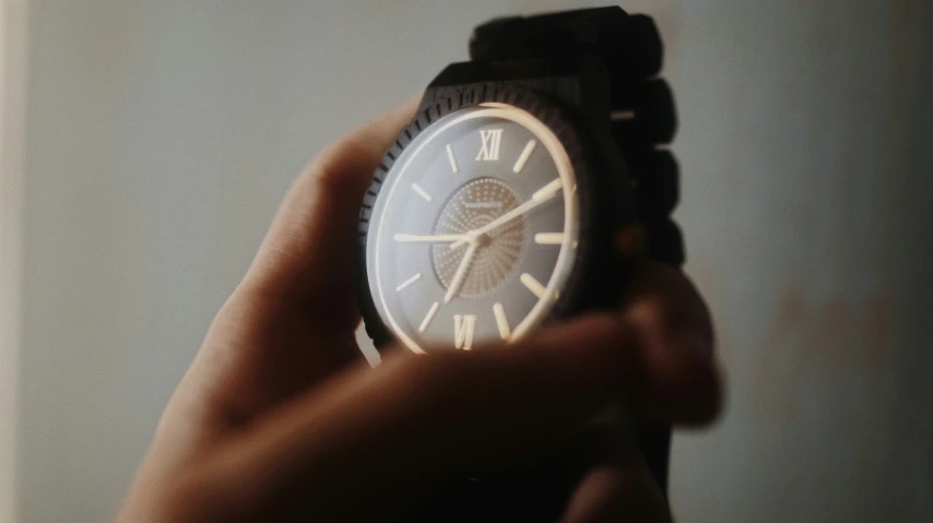 hand with a watch in it that has a design on the dial
