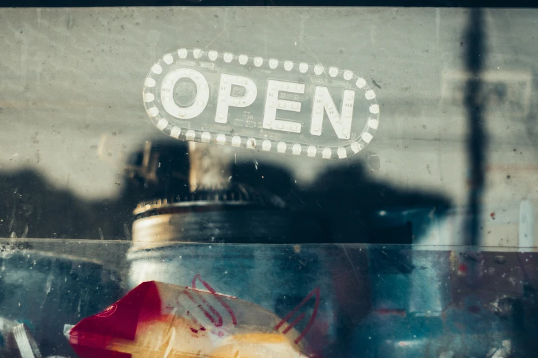 a close up view through a glass window at a open sign