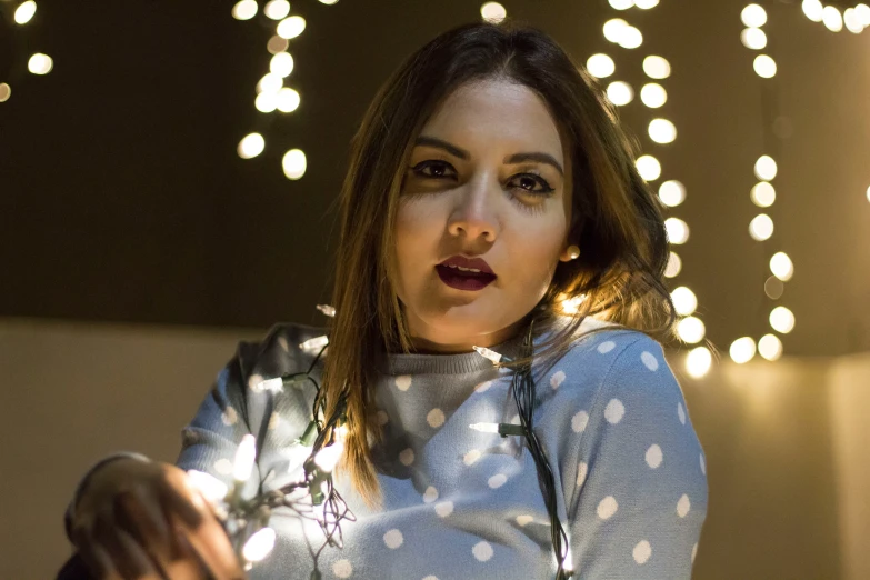 a young lady with long dark lipstick standing in front of some lights