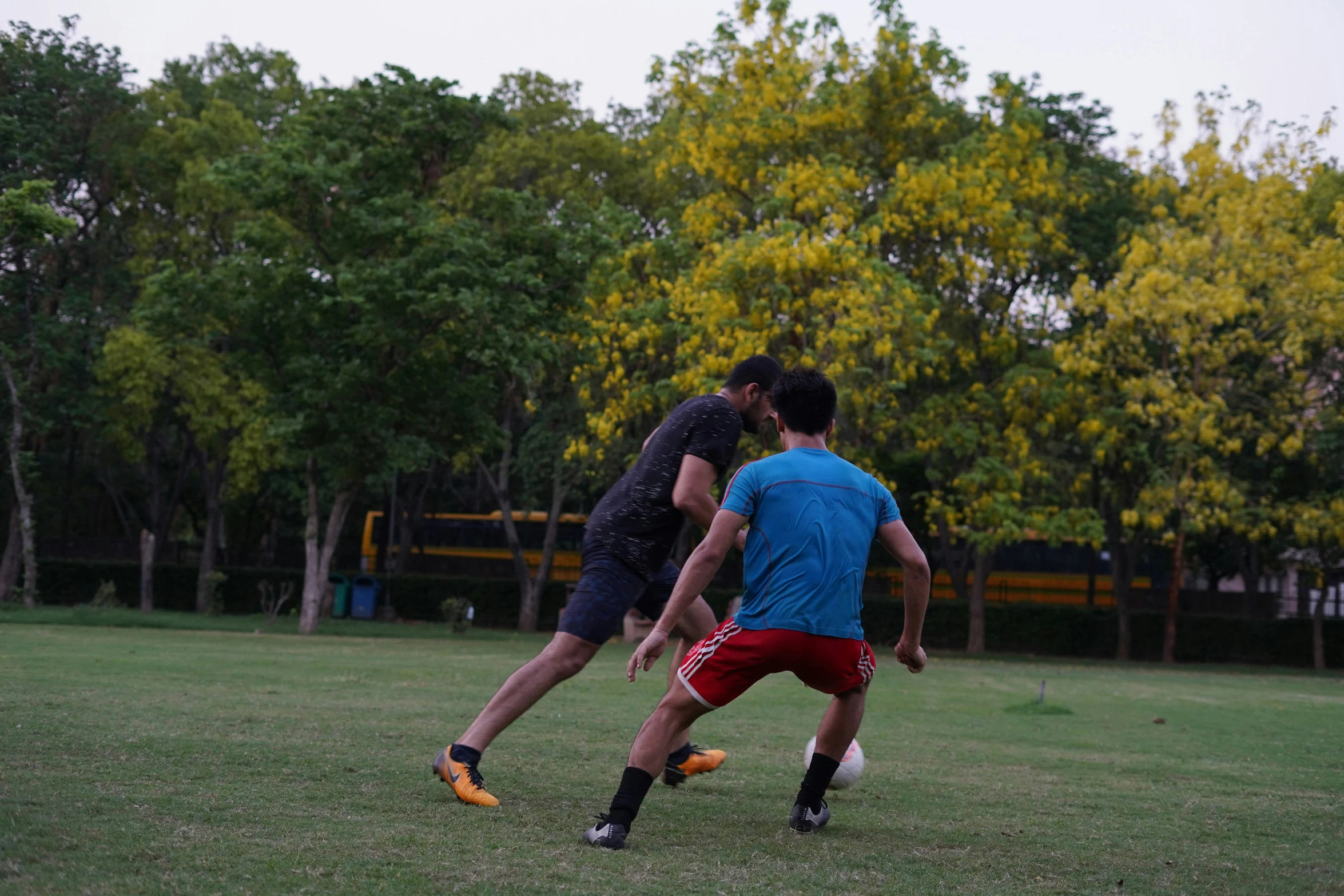 two young men playing soccer together on a field